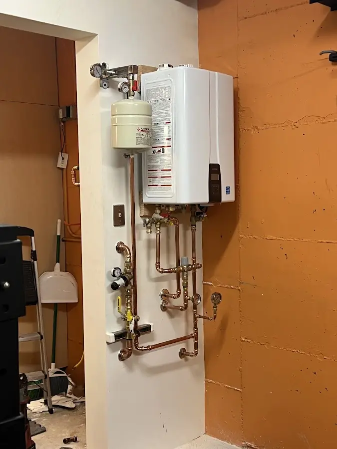 Plumbing technician inspecting water heater connections in Landover